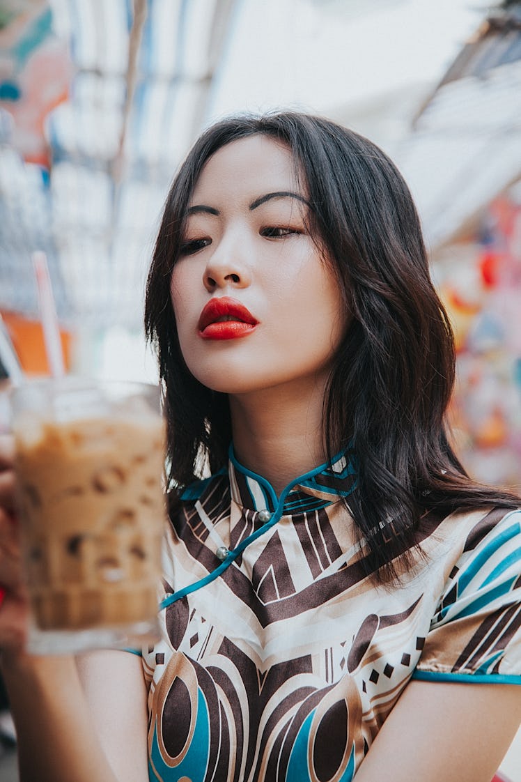 Young woman unhappily sipping a coffee after learning her zodiac sign will have the worst month of J...