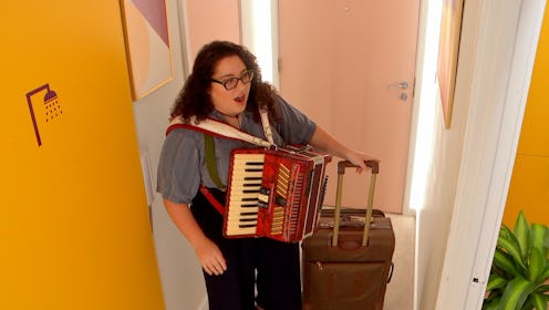 Rachel Evans in 'The Circle' Season 4, standing inside a door, holding a brown suitcase and wearing ...