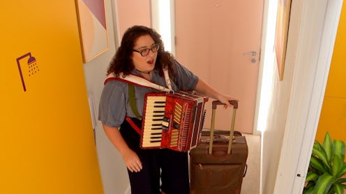 Rachel Evans in 'The Circle' Season 4, standing inside a door, holding a brown suitcase and wearing ...