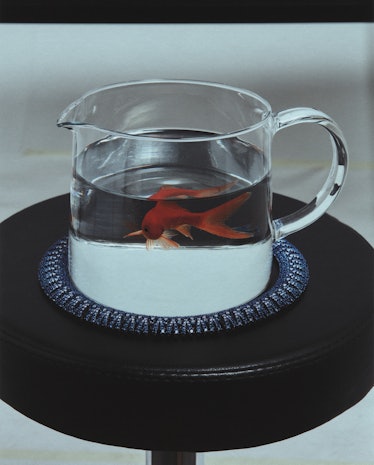 Chopard necklace around a glass mug with a fish in it