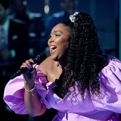 lizzo wears scrunchie and purple puff sleeved dress