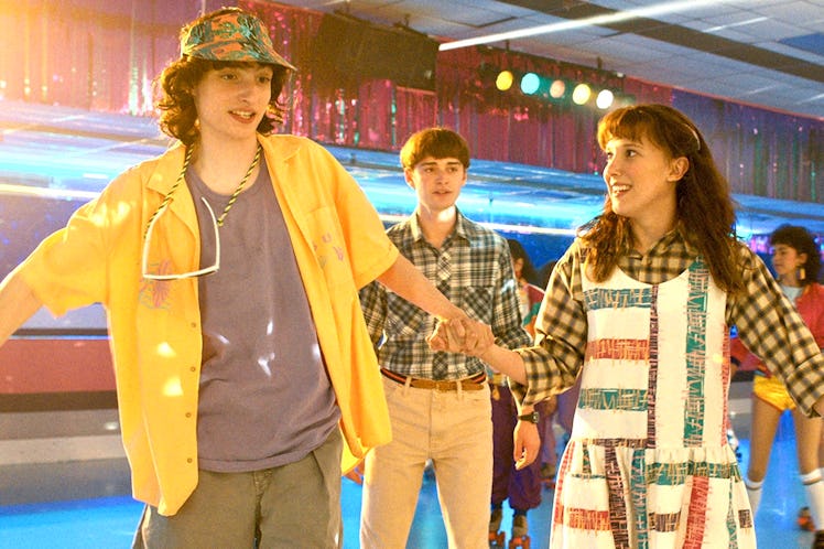 Mike, Will, and Eleven roller skating in 'Stranger Things' Season 4 with their retro fashions.
