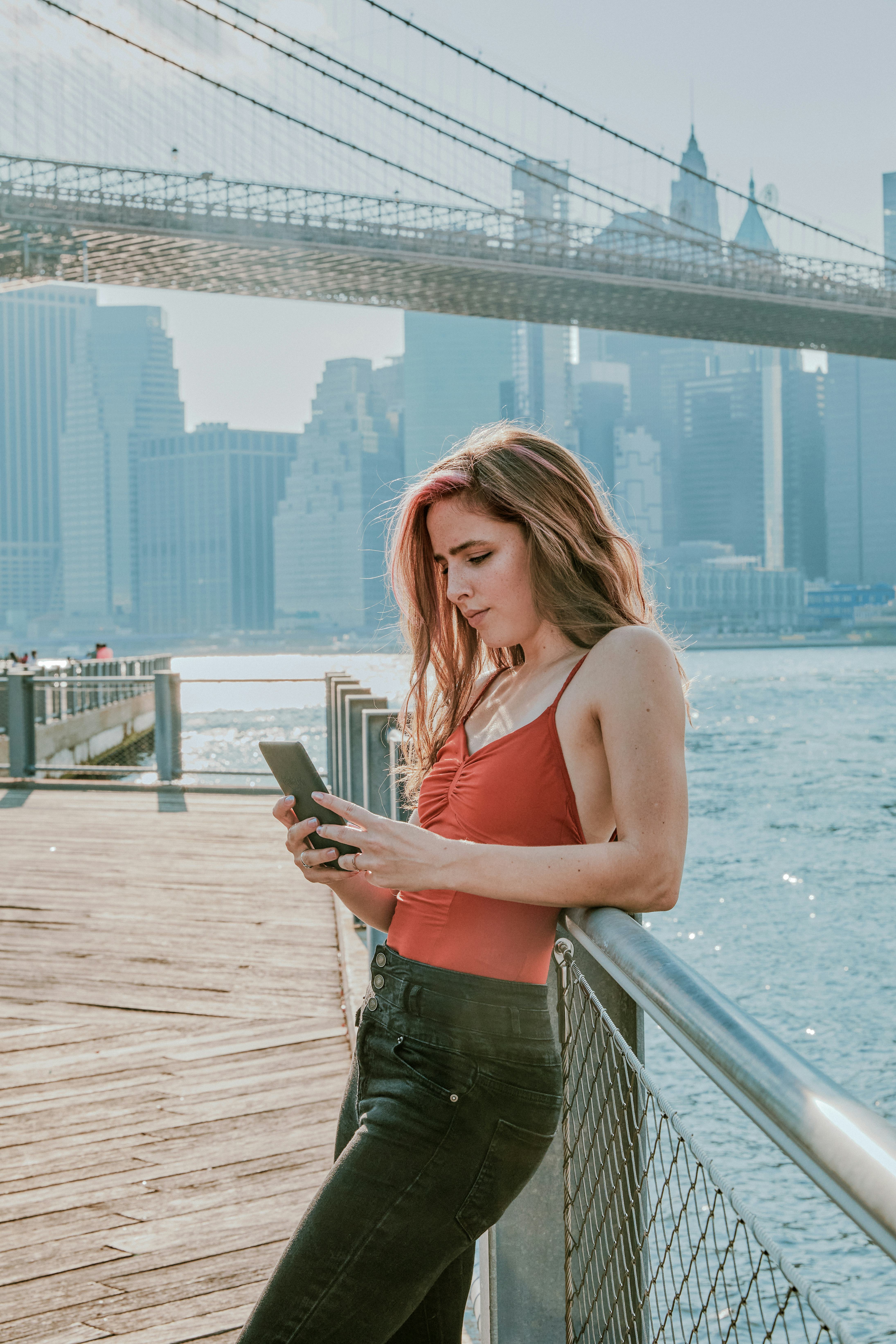 Young woman texting by a bridge on June 3, when Mercury retrograde spring 2022 ended.