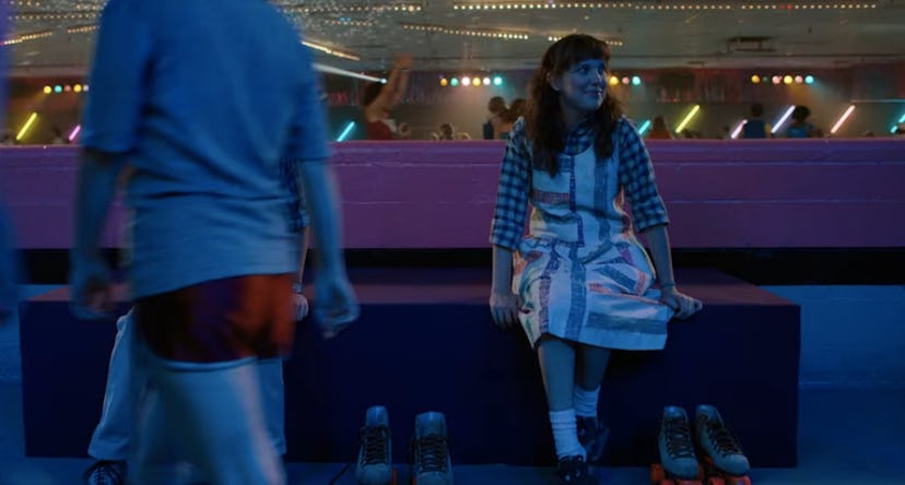 eleven wearing a printed dress with a flannel shirt in stranger things season 4