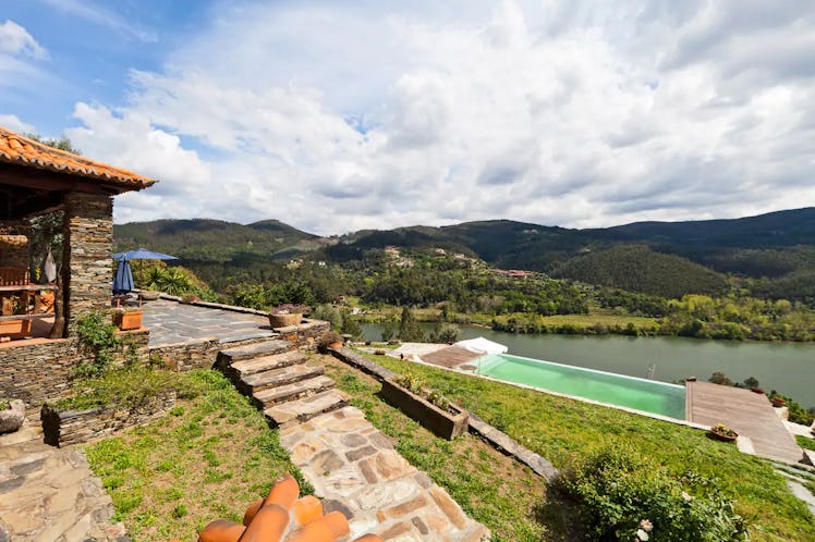 An infinity pool in Portugal overlooks the hills at an Airbnb home.