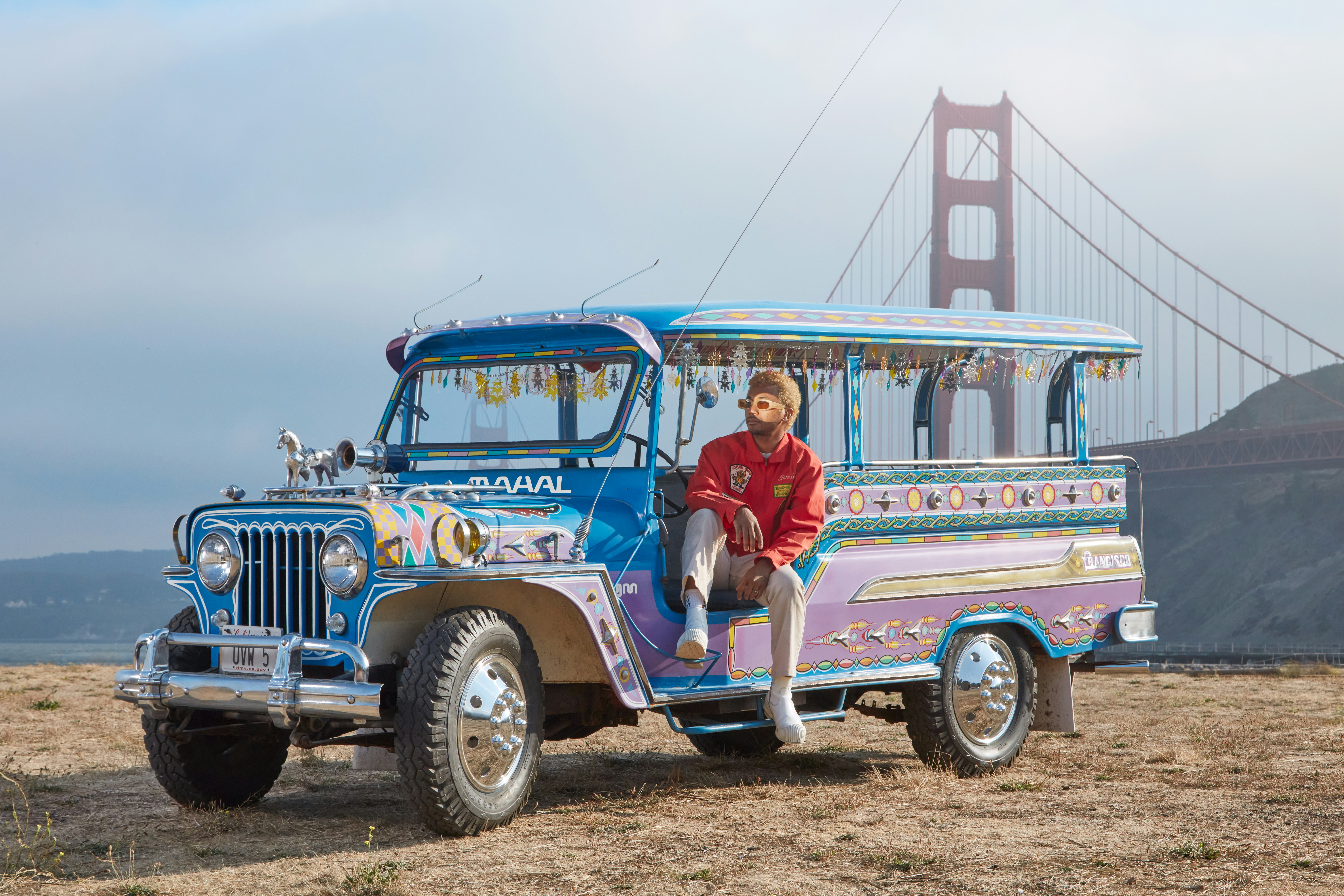 Toro Y Moi in a blue city tour car near the Golden Gate bridge