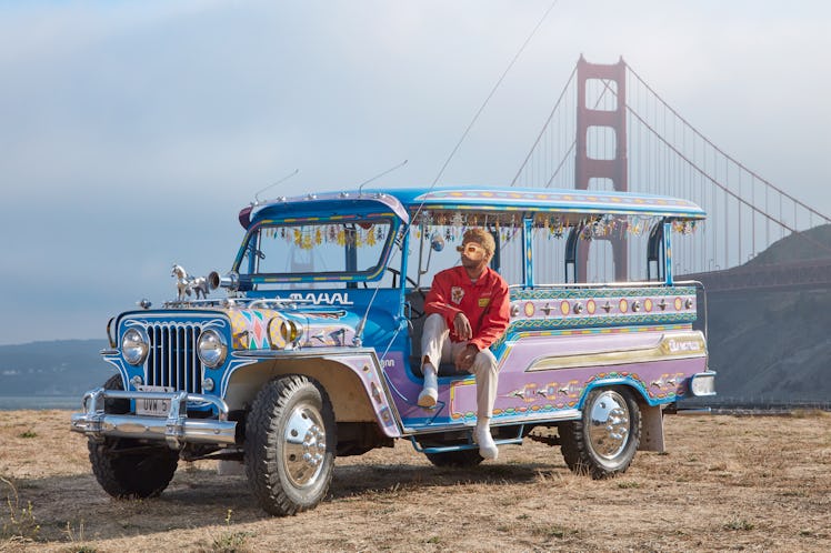 Toro Y Moi in a blue city tour car near the Golden Gate bridge