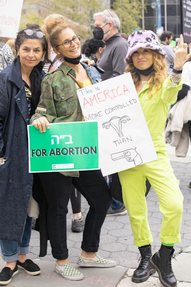Three people holding signs at a pro-choice protest at Foley Square in Manhattan