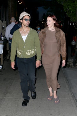 Sophie Turner wears brown dress and fuzzy house slippers.