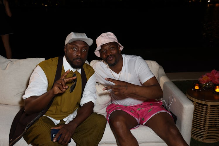 will.i.am and a friend sitting on a couch