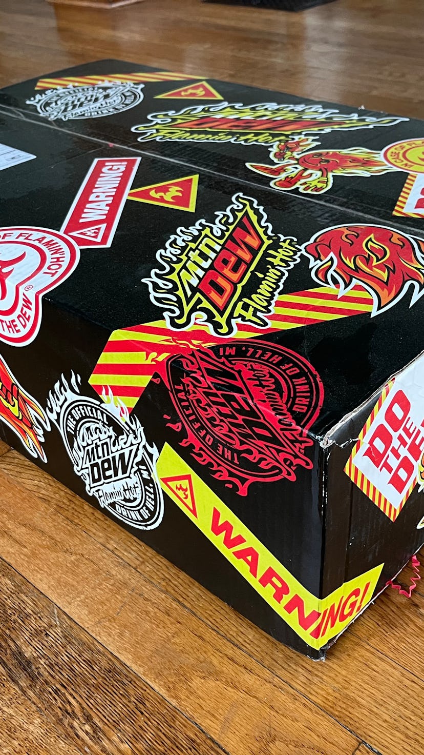Promotional box of Flamin Hot Mountain Dew on wooden floor