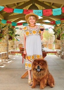 Martha Stewart holding a Martha-rita while at her farm with her dog