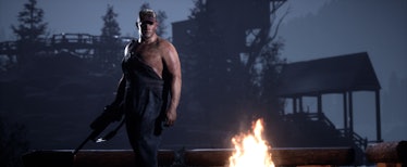 A character from The Quarry wearing overalls while standing next to a camp fire