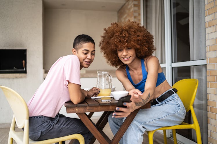 Young couple taking a selfie on the balcony of their first apartment.