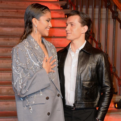 Zendaya holding her hand to her heart while looking at Tom Holland