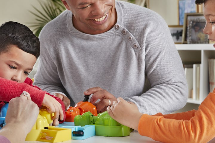 Dad sitting and playing with his sons while smiling