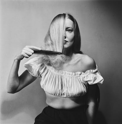 A fashion model demonstrates combing her hair on 24th September 1949 in London, United Kingdom. Imag...