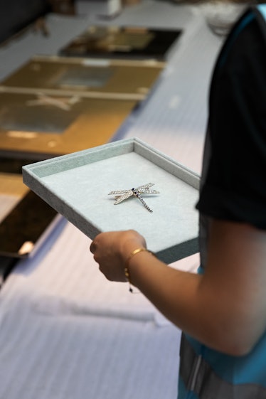the tiffany dragonfly brooch being carried on a robins egg blue velvet tray