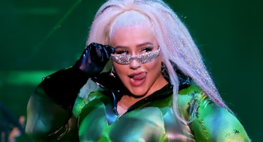Christina Aguilera wearing green breastplate with sparkly green strap on and chaps