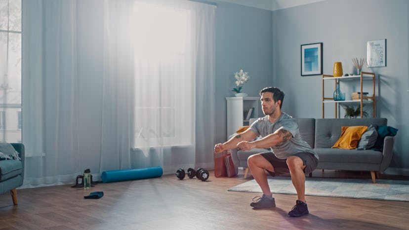 A man doing squats during an at-home workout.