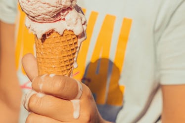 Close up of melting ice cream cone in kid's hand