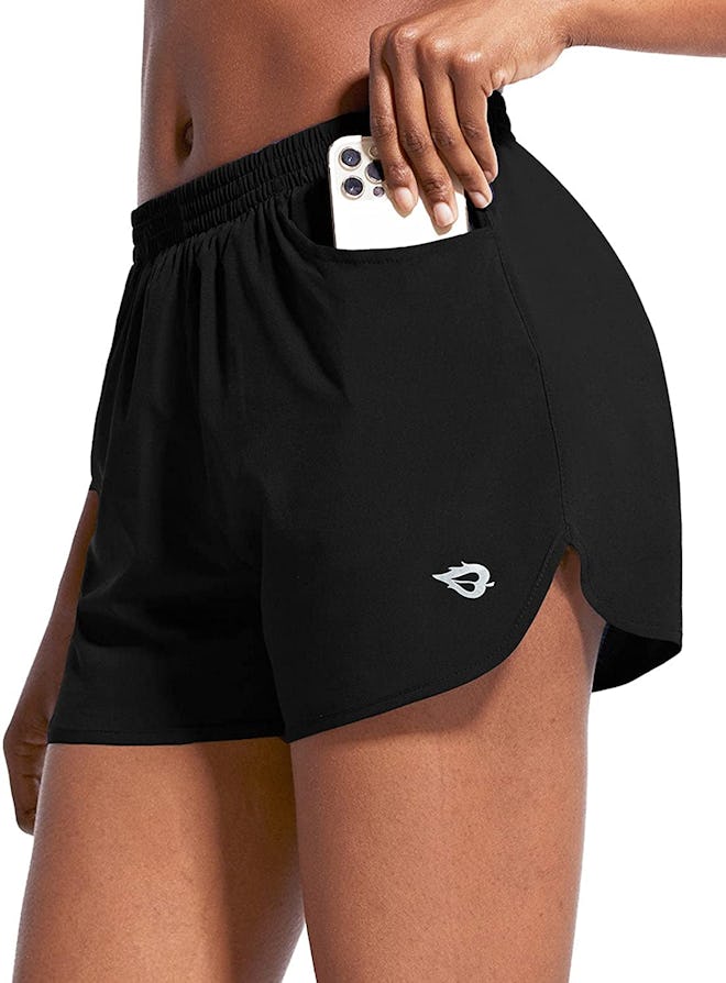 BALEAF quick dry shorts in black, with model holding a phone half in short pocket