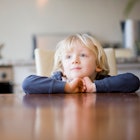 A child waits patiently at the dinner table.