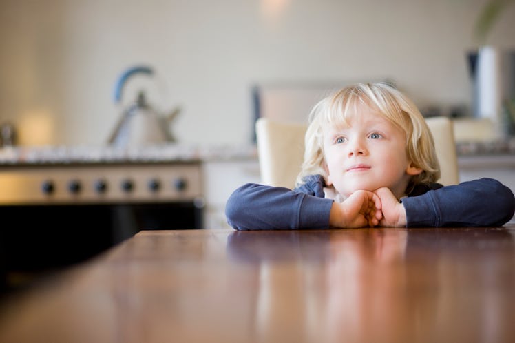 A child waits patiently at the dinner table.