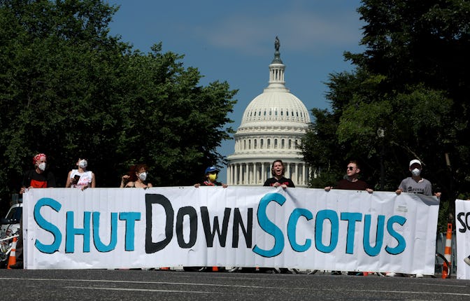 Protesters hold a banner near the U.S. Supreme Court in Washington, D.C. The Supreme Court ruled Wed...