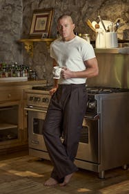 Channing Tatum holds a coffee mug in a kitchen in a white T-shirt