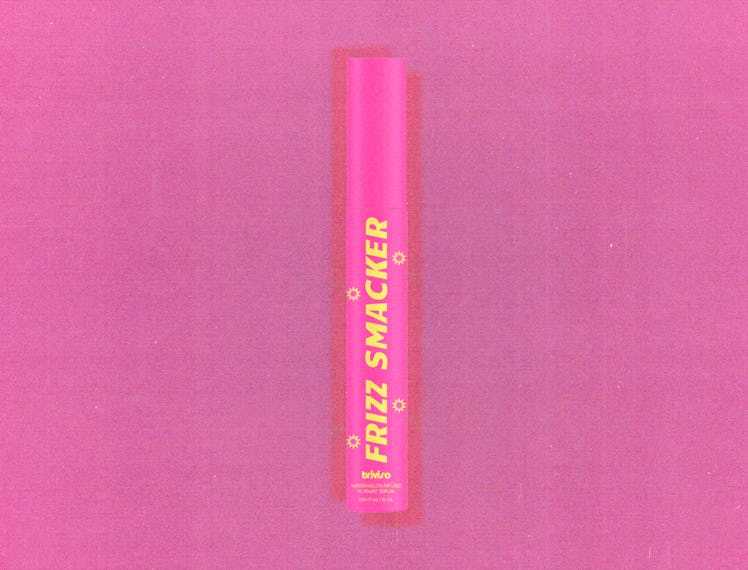 A tube of hair serum called Frizz Smacker against a pink backdrop