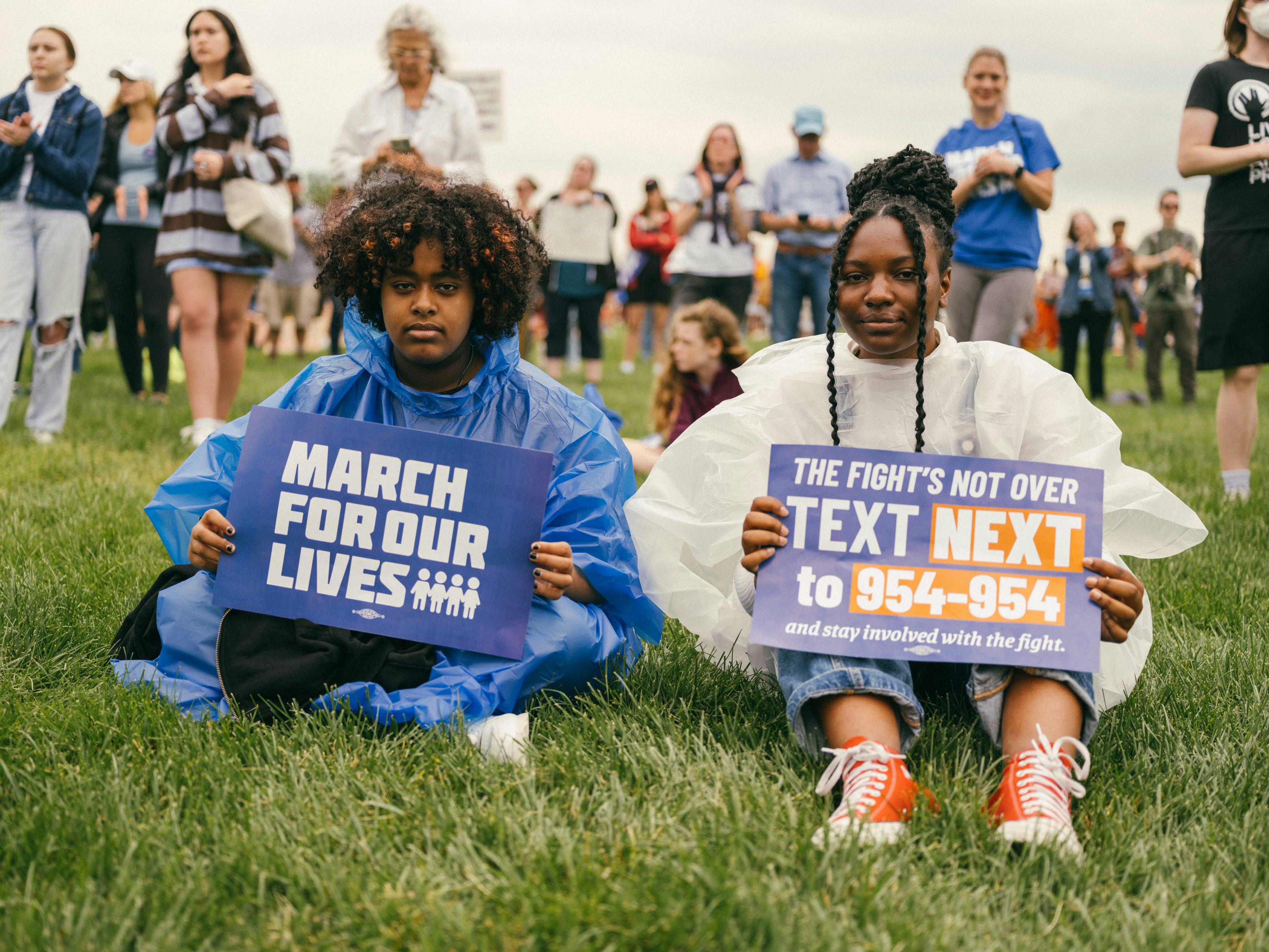 Two young protestors at the March for Our Lives rally in Washington, D.C. holding signs made by the ...