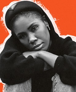 Yuri Carter in a black sweater, leaning her arms and head on her knees while posing
