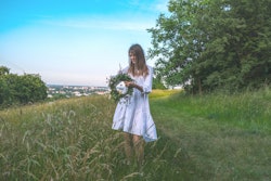 A woman picks a flower crown to wear during Poland's midsummer festivities. The spiritual meaning of...