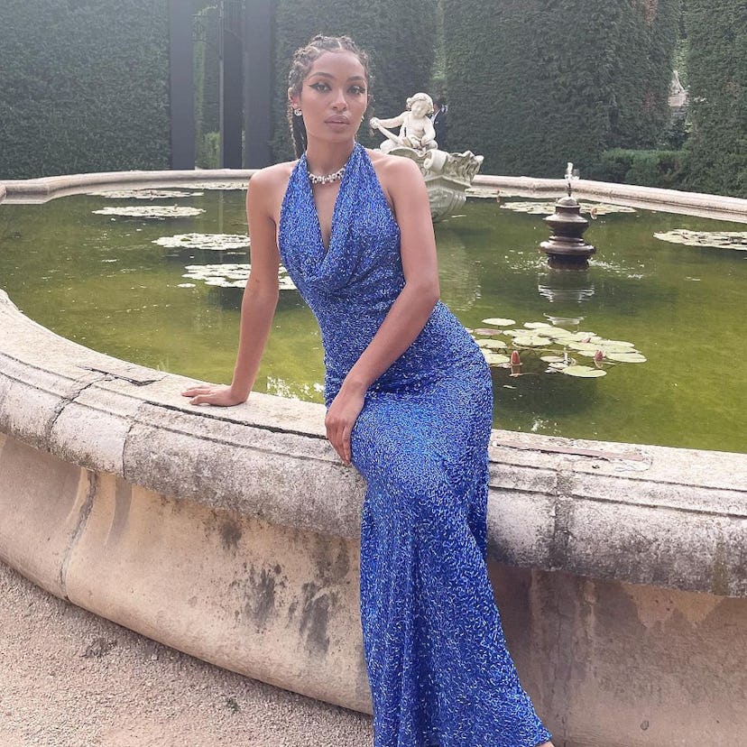 Yara Shahidi sitting on the edge of a fountain wearing a sparkling blue dress and her take on the cl...