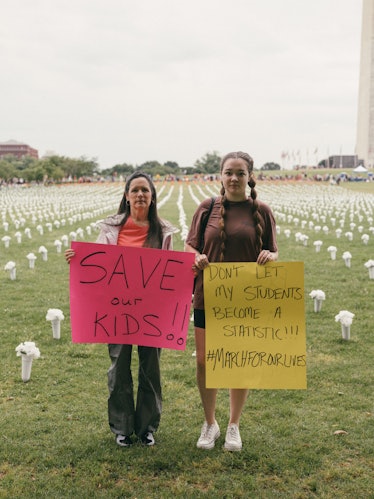 Two protestors standing in front of the flowers positioned under the Washington Monument that symbol...