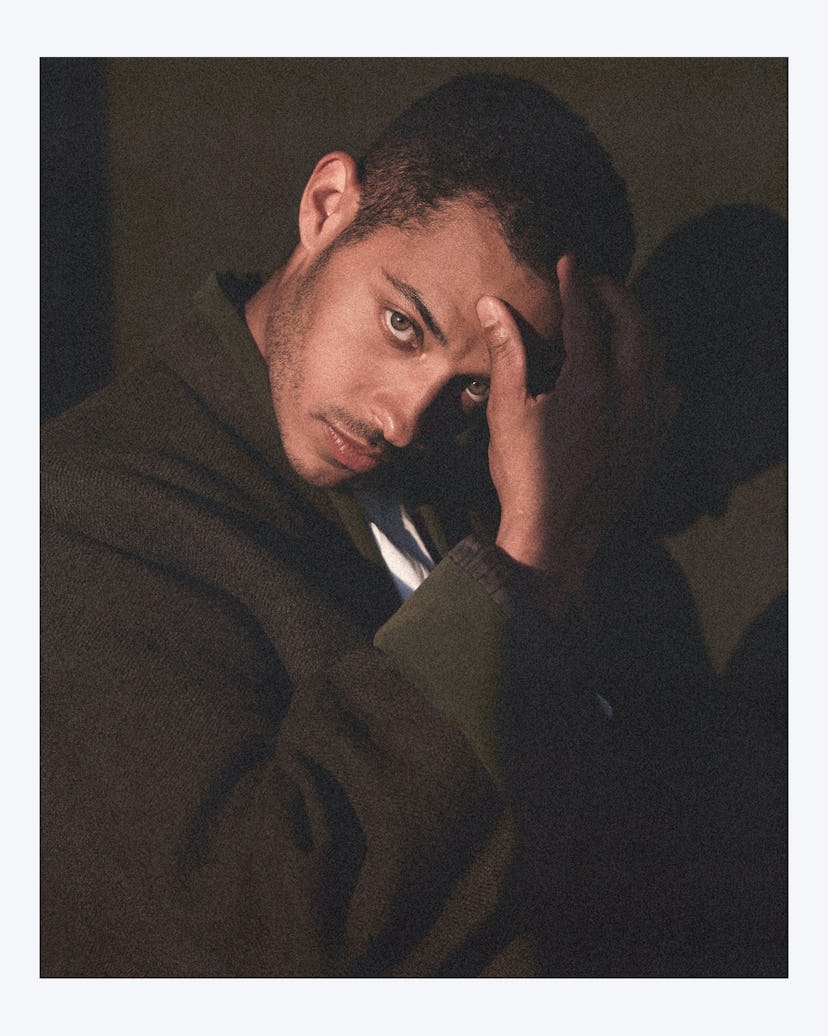 Daryl McCormack wearing a brown blazer and staring pensively at the camera with his hand on his fore...