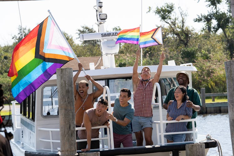 Fire Island cast holding LGBT flags on a boat