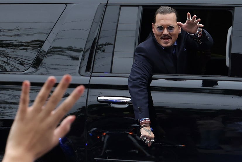Actor Johnny Depp waves to supporters from his vehicle as he leaves a Fairfax County Courthouse May ...