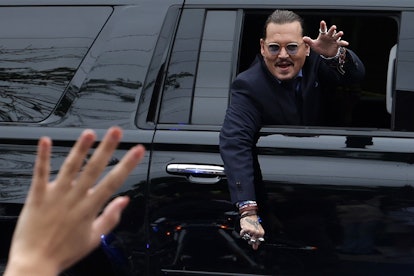 Actor Johnny Depp waves to supporters from his vehicle as he leaves a Fairfax County Courthouse May ...