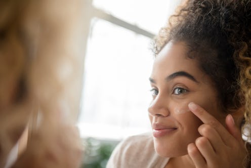 Woman applying sunscreen to her face.