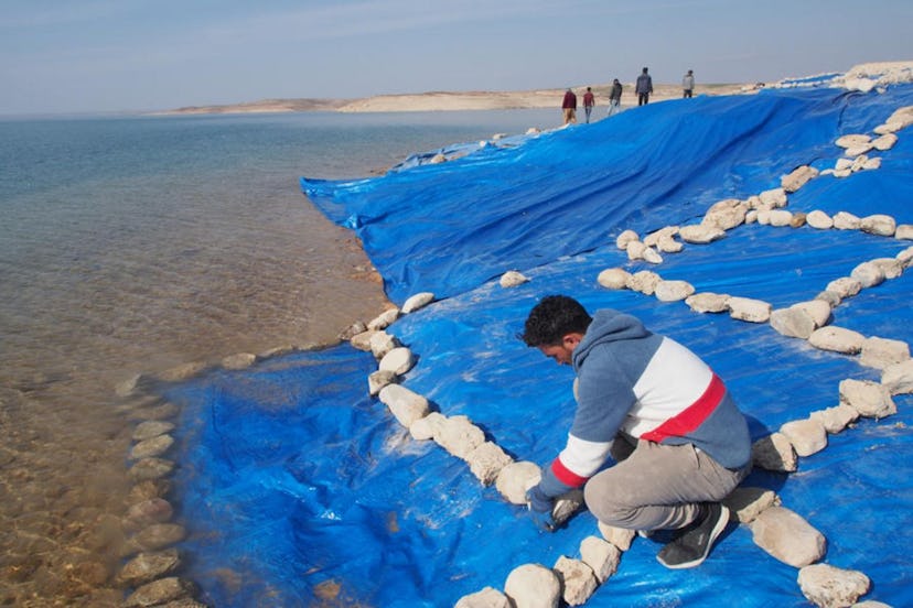 After the research team has completed their work, the excavation is covered extensively with plastic...