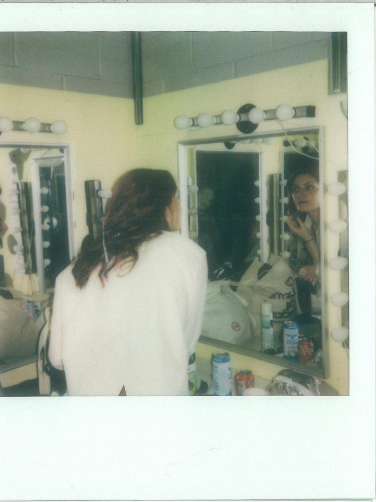 A polaroid of Katie Gavin getting ready in front of a mirror