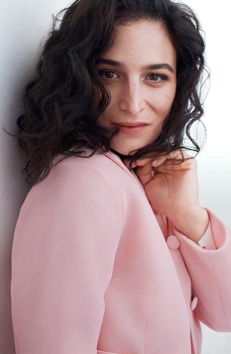 A close up of Jenny Slate posing in a Mollusk-pink jacket by Sandy Liang