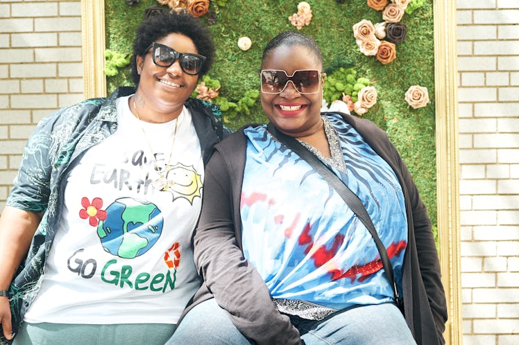 A person wearing a white tee posing next to a person wearing sunglasses