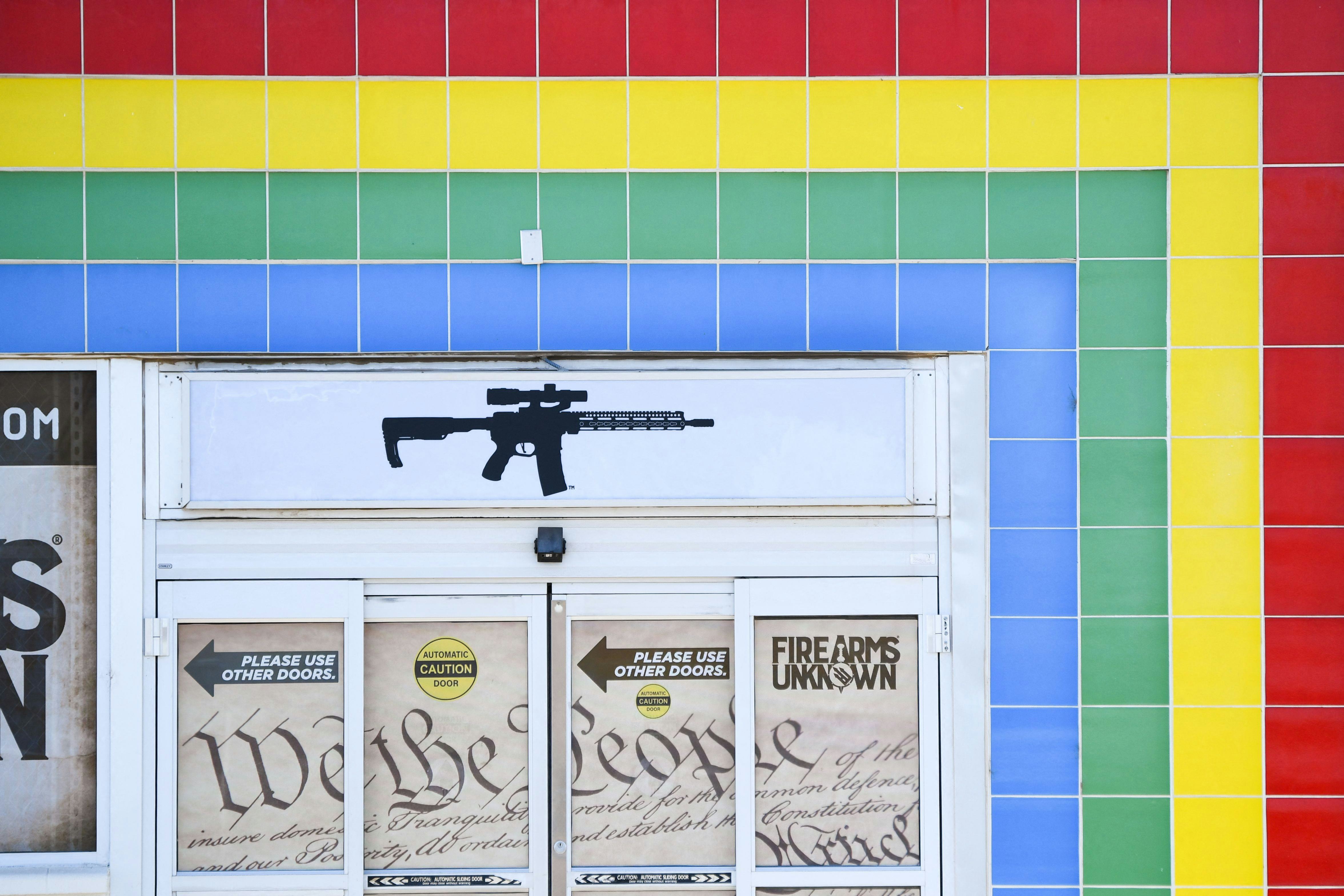 The silhouette of an AR-15 style rifle is displayed on signage for the Firearms Unknown Guns & Ammo ...