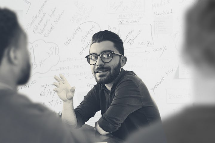 A man talking to his co-workers at work