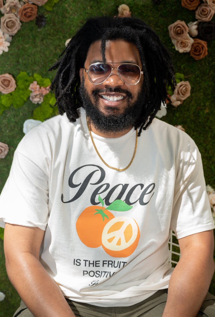 A person wearing a white tee that reads "peace"