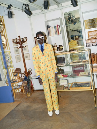 A person wearing a yellow Gucci HA HA HA suit