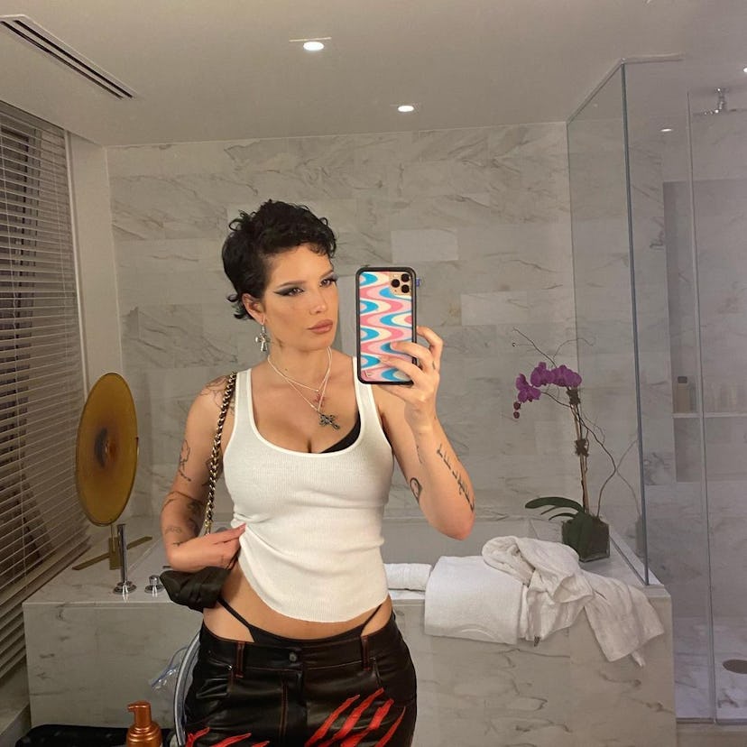 halsey wearing a white tank with black pants and a black g-string 